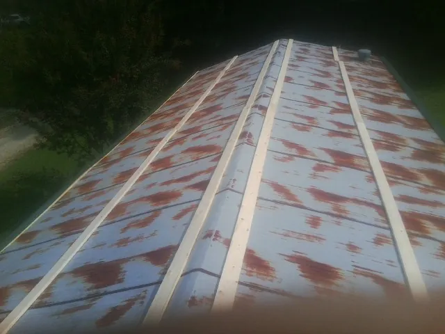 Rusted metal roof panels with new wood purlins before replacement — Storm Damage Roof Repair in Cofield by Roofing Brothers