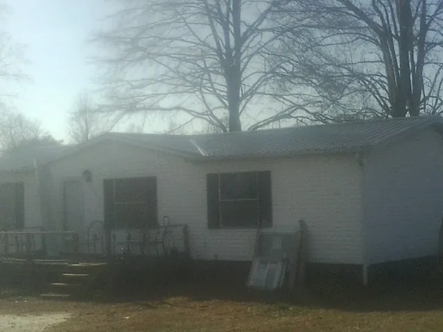 New metal roof on a white painted brick home on a foggy morning in Cofield