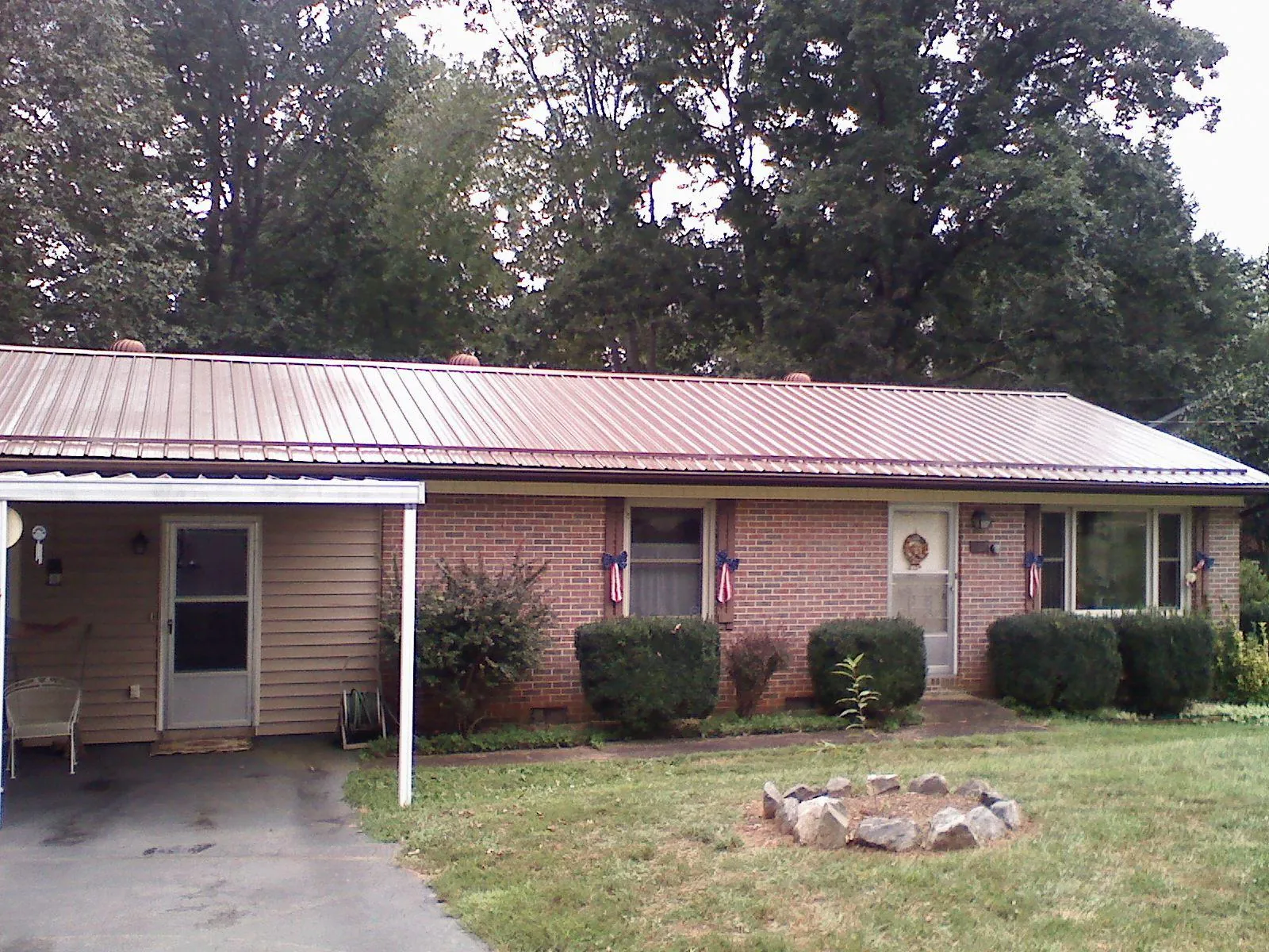 Bronze metal roof and carport on a brick ranch home — Roof Repair work by our crew in Cofield